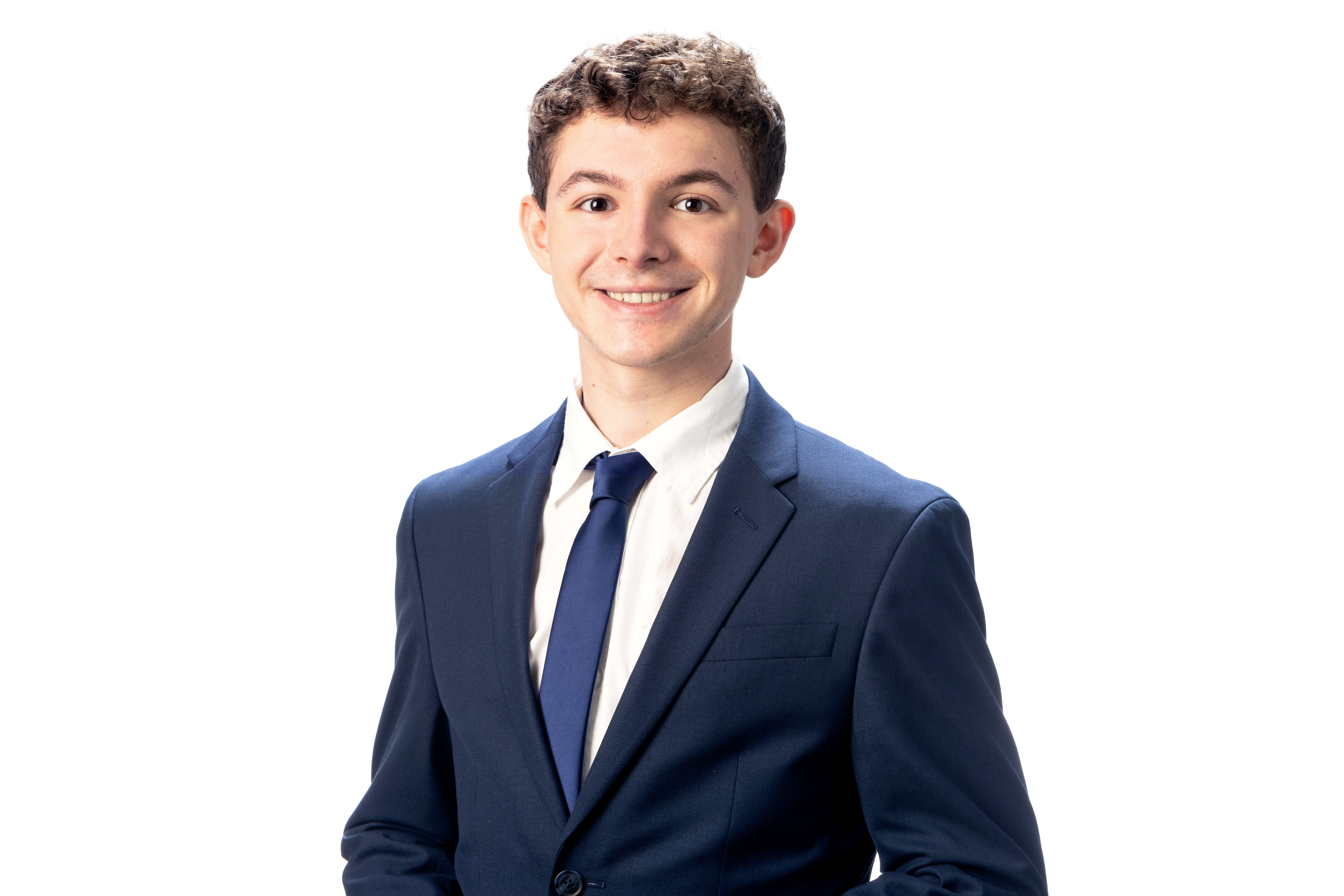 Andrew in front of a white background wearing a navy blue suit and tie with white shirt