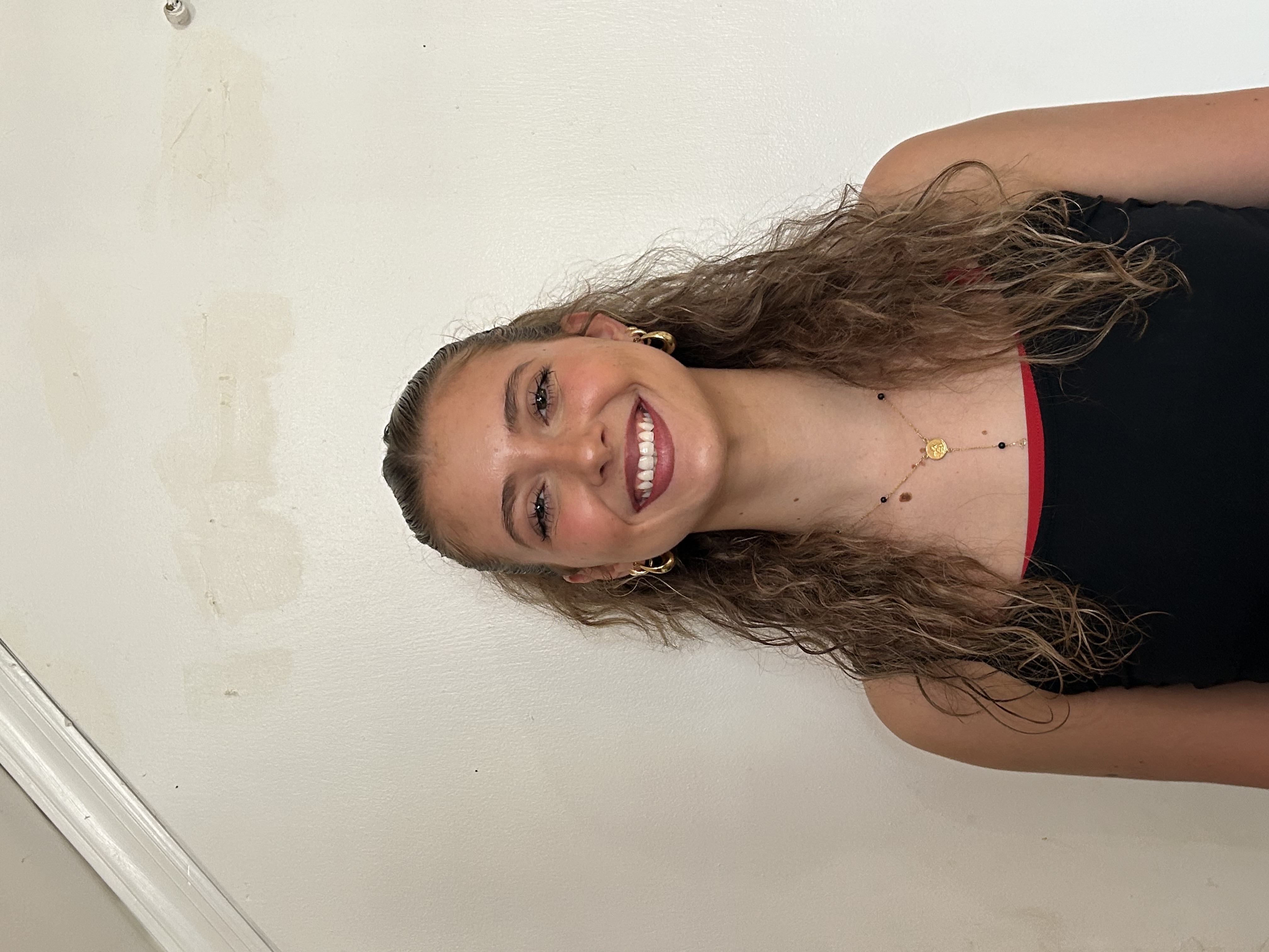 chloe in front of a white background wearing a black tank top