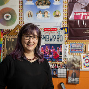 Mellie standing in front of a decorated bulleting board with misc. flyers