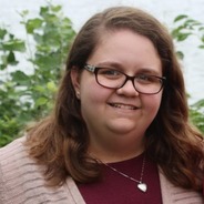 jen rieder smiling in front of green trees