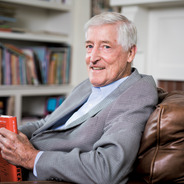 Charles Marcon at home with a book